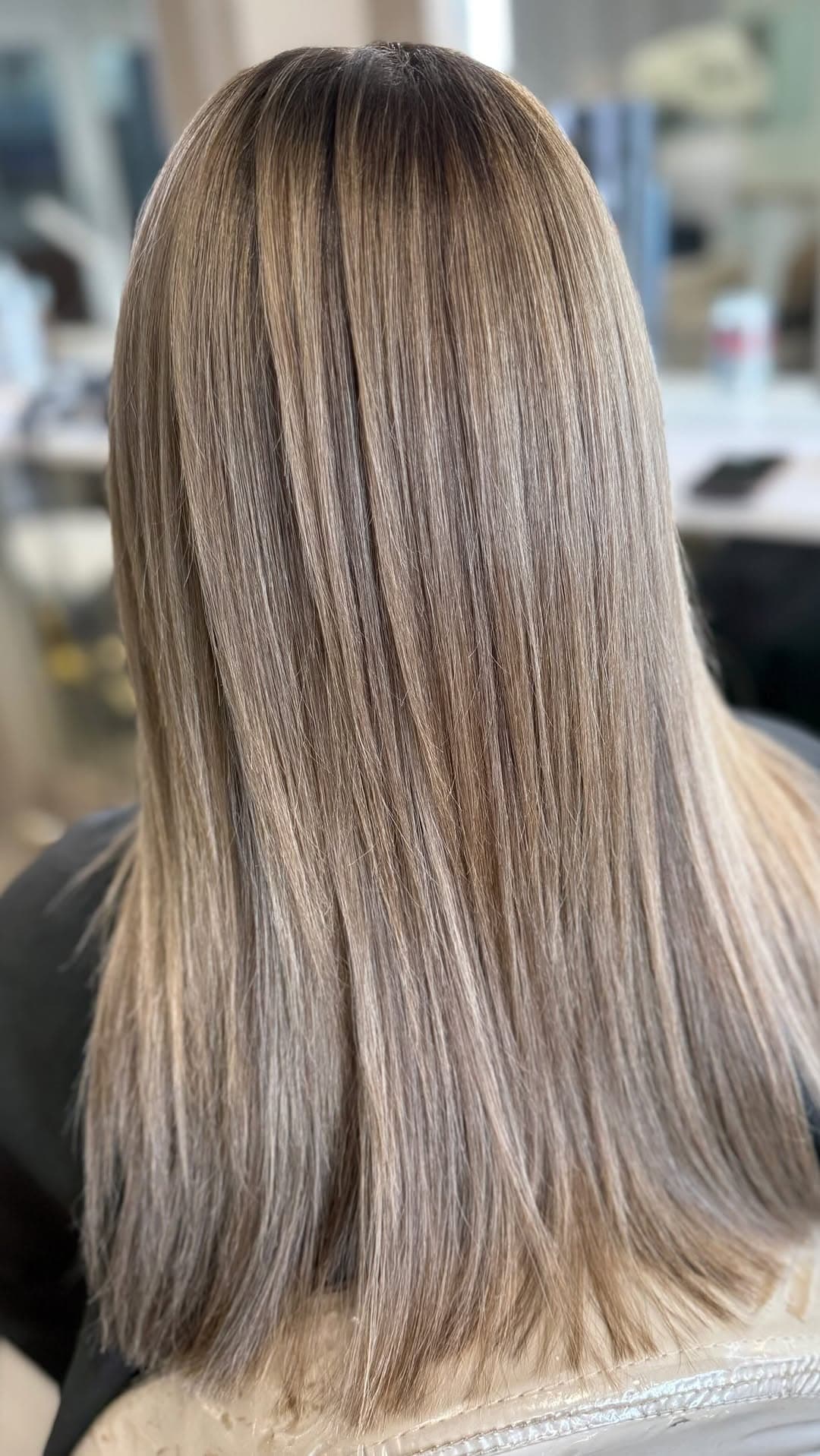 A straight, sleek bronde-beige cascade catching the salon light.